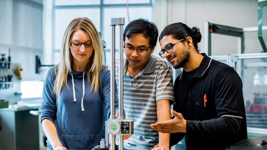 Students collaborating on a measurement device in an engineering lab