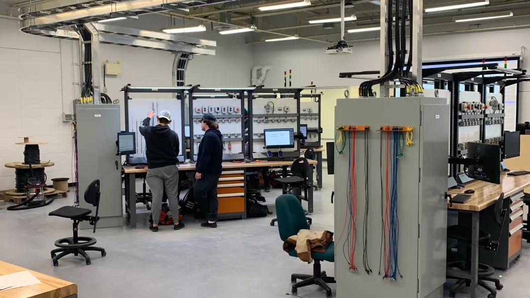 Image Alt Generator said:  Students working together at electrical training stations in the lab