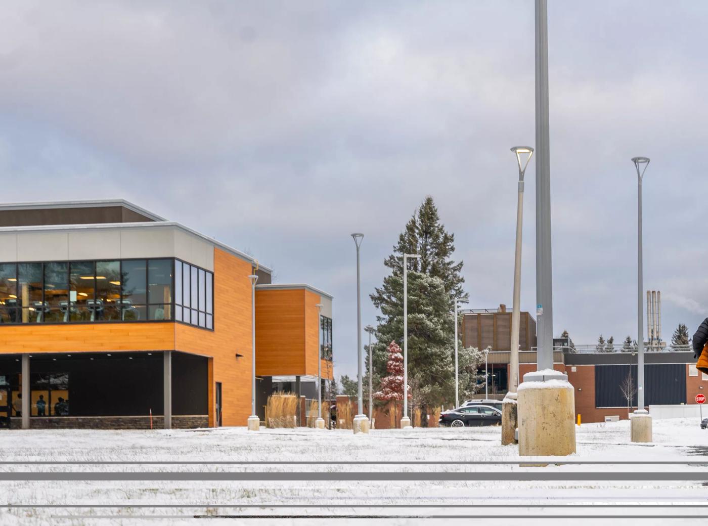 Confederation College campus building in winter with snow-covered ground and overcast sky