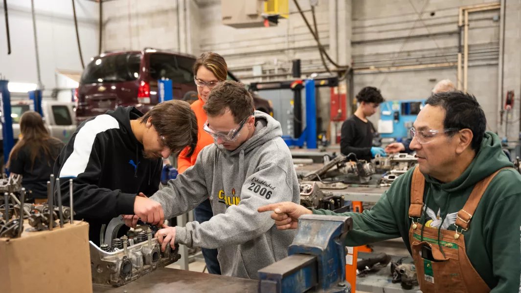 Students collaborating on engine repair in the automotive shop