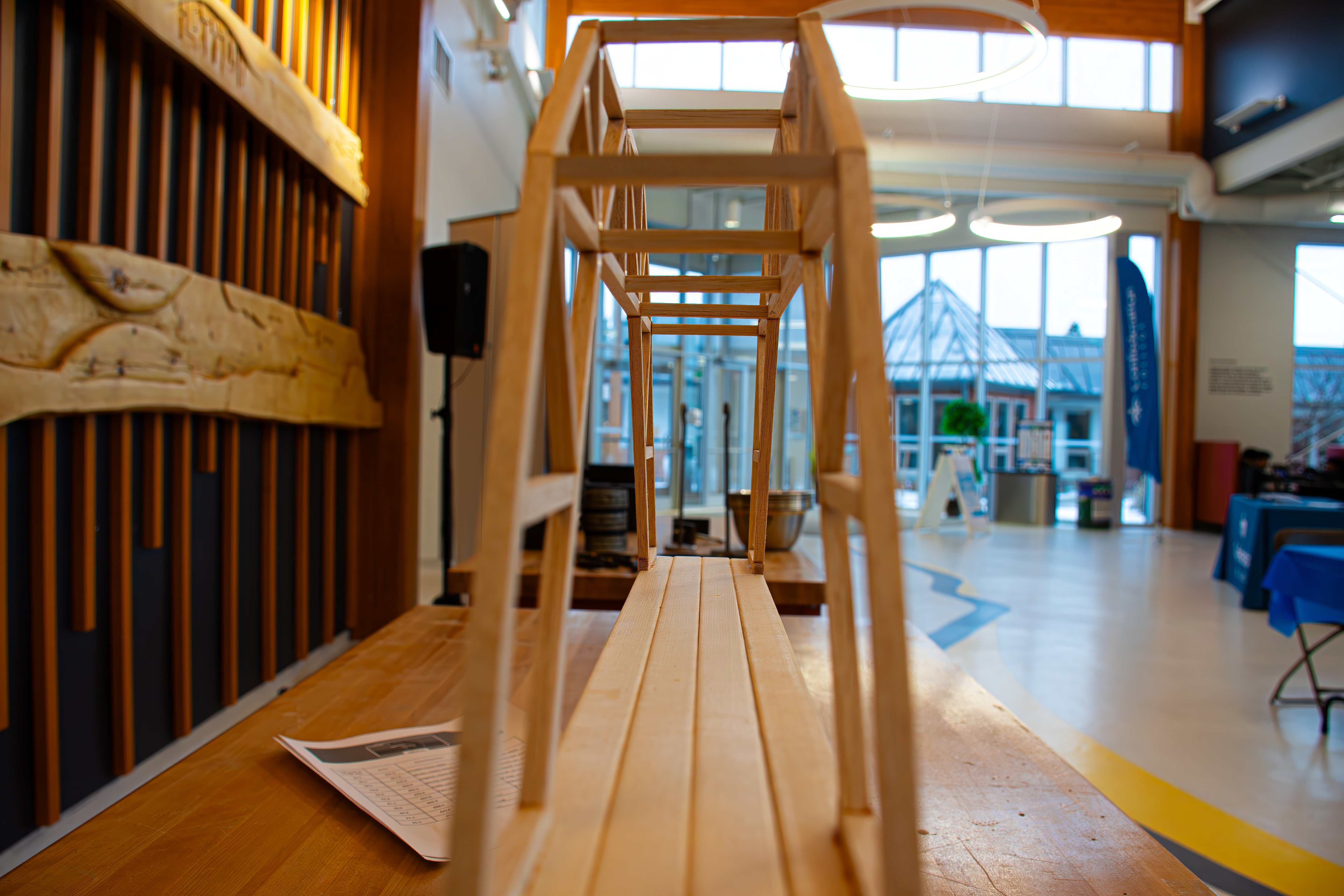 Wooden bridge model displayed for structural testing at a Confederation College engineering event