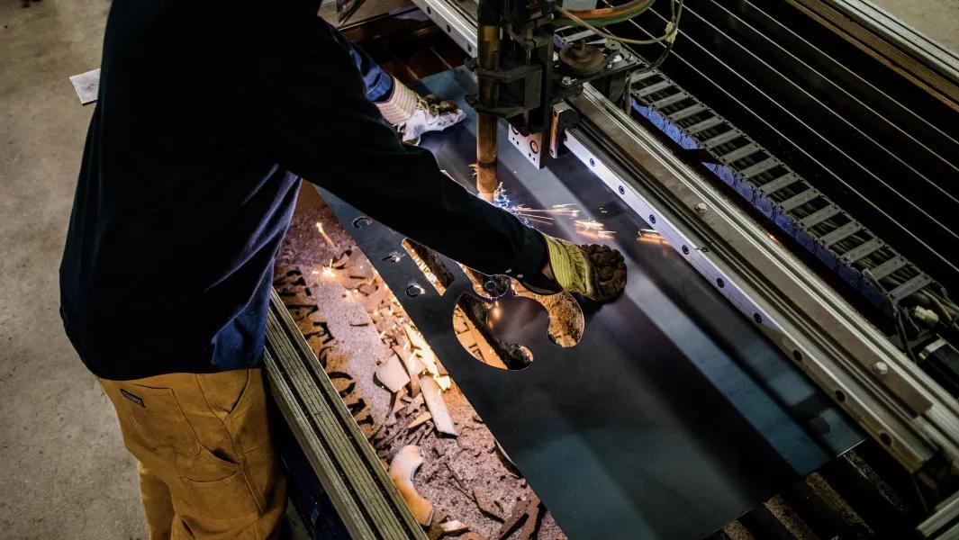 Student operating a CNC plasma cutter to shape metal