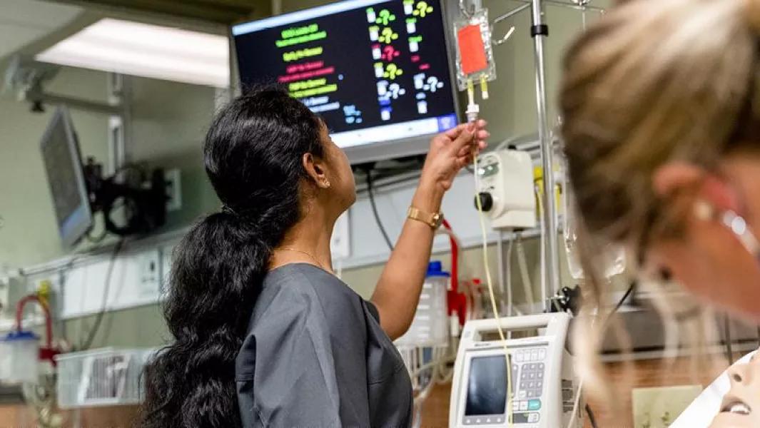 Nursing student checking an IV setup in the simulation lab