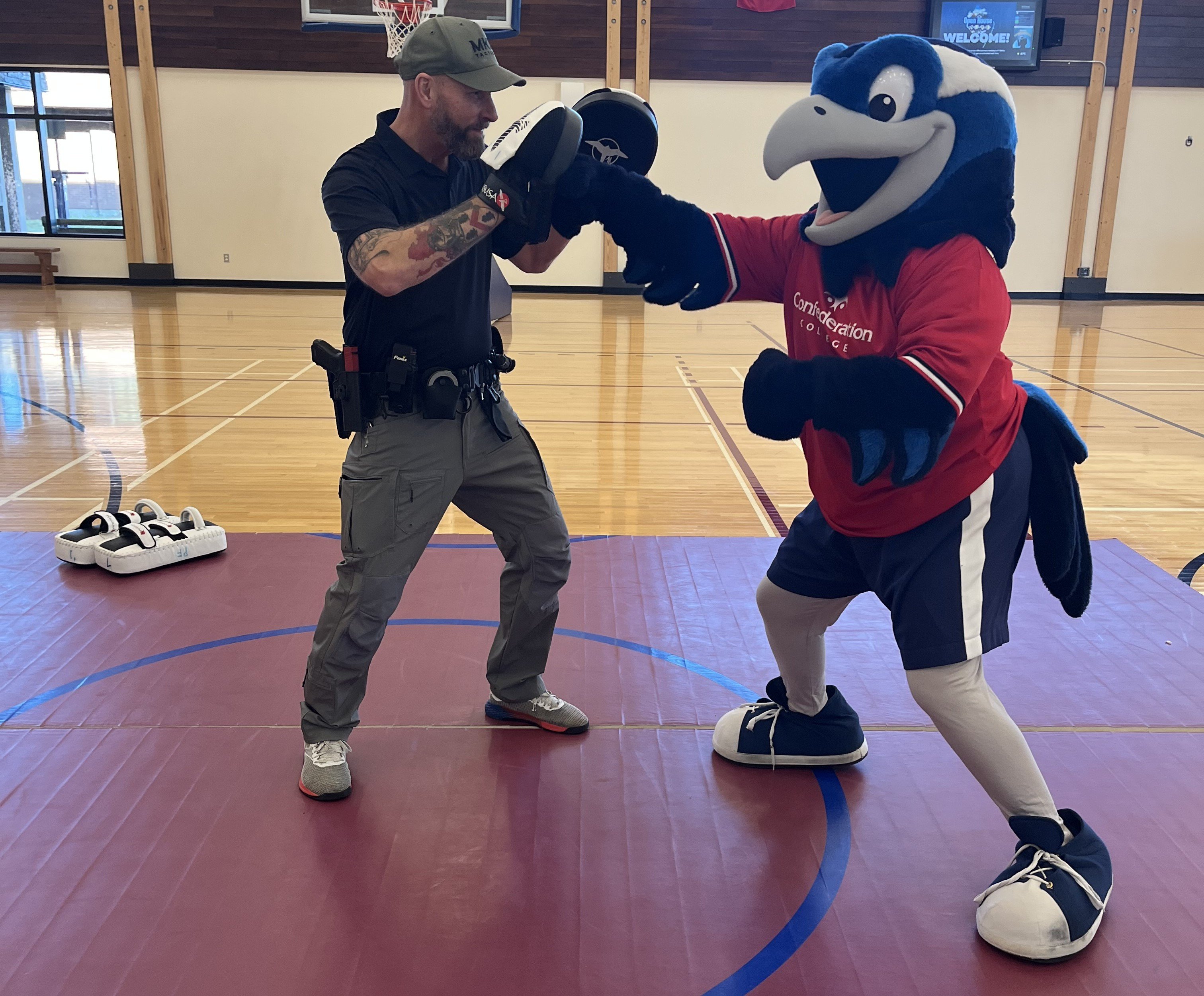 College mascot practices boxing drills with a police instructor