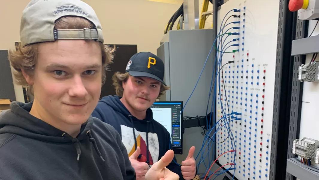 Students working on an electrical control panel in the lab