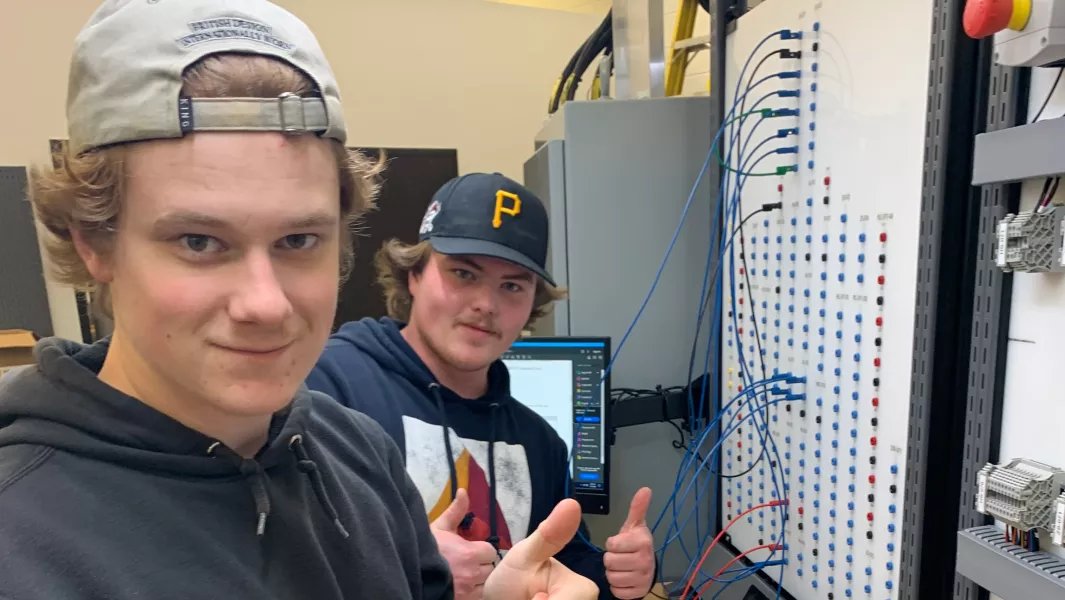 Students working on an electrical control panel in the lab