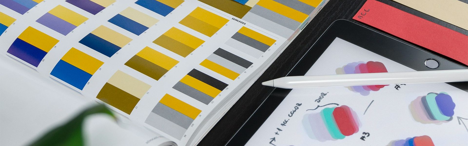 Graphic design workspace with color palettes, swatches, and tablet-based colour scheme planning