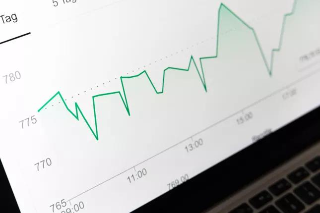 Upward trending financial chart on laptop screen