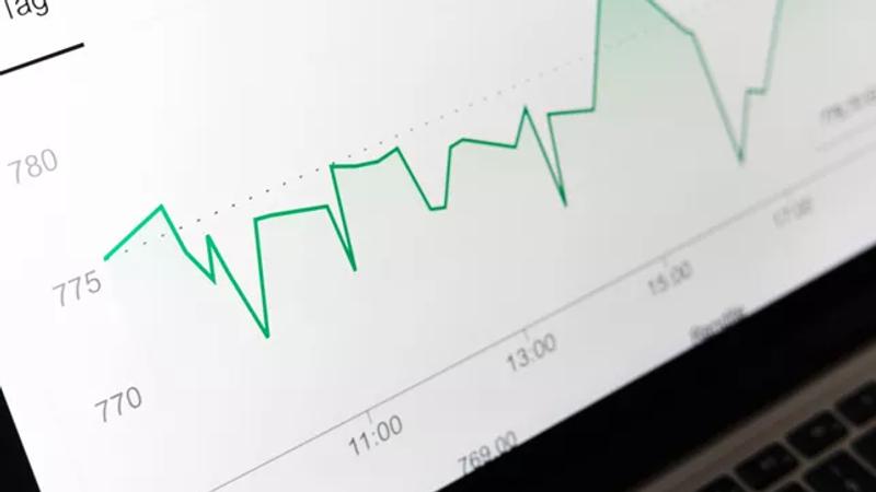 Upward trending financial chart on laptop screen
