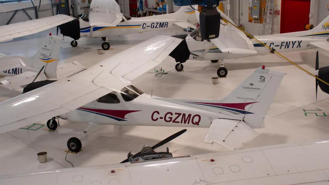 Training aircraft parked in the aviation hangar for maintenance