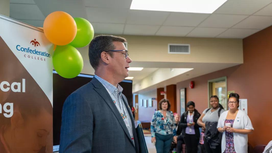 Confederation College staff member speaking to a group during a campus event