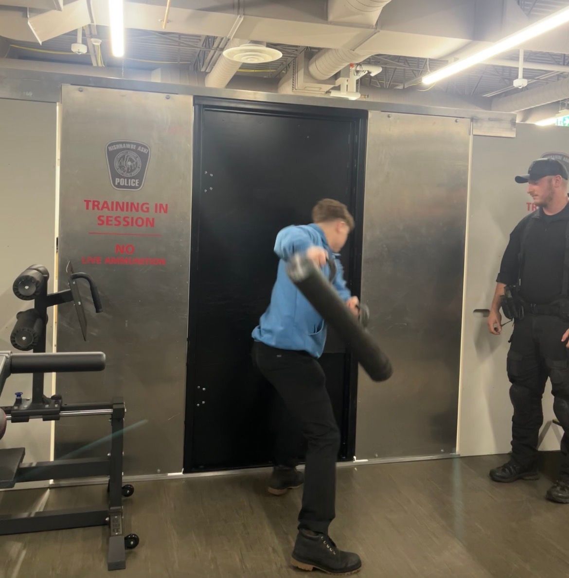 Trainee practices forced entry using a battering ram during police training