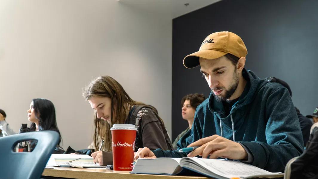 Students focused on reading and note-taking in a classroom