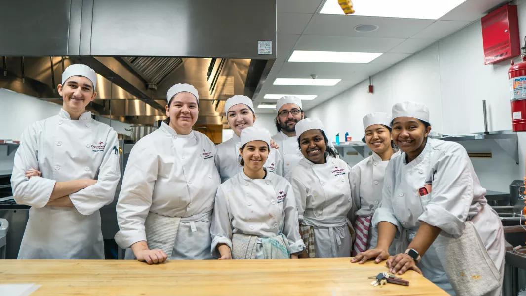 Culinary students posing together in the teaching kitchen