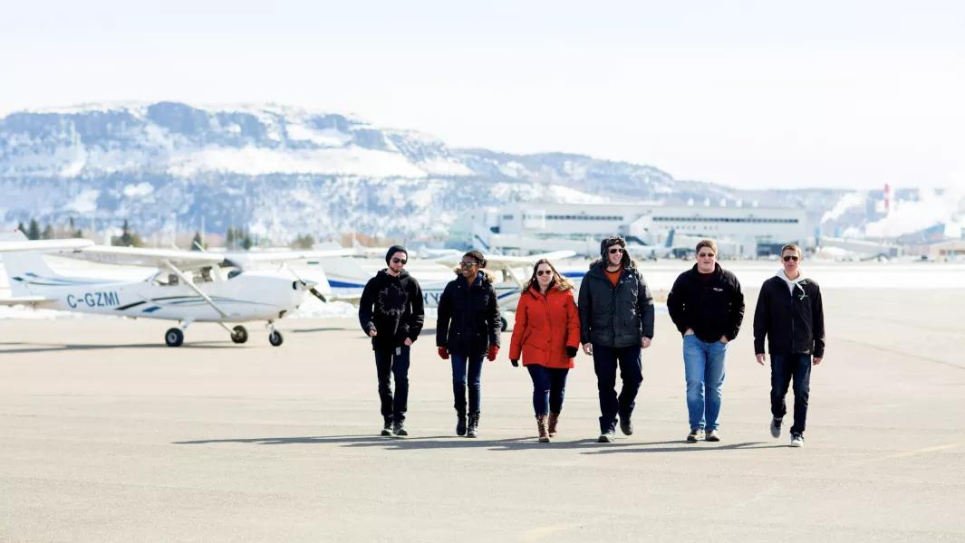 Aviation students walking across the tarmac beside training aircraft