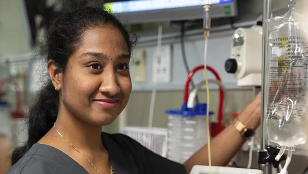 Nursing student adjusting an IV line in the simulation lab