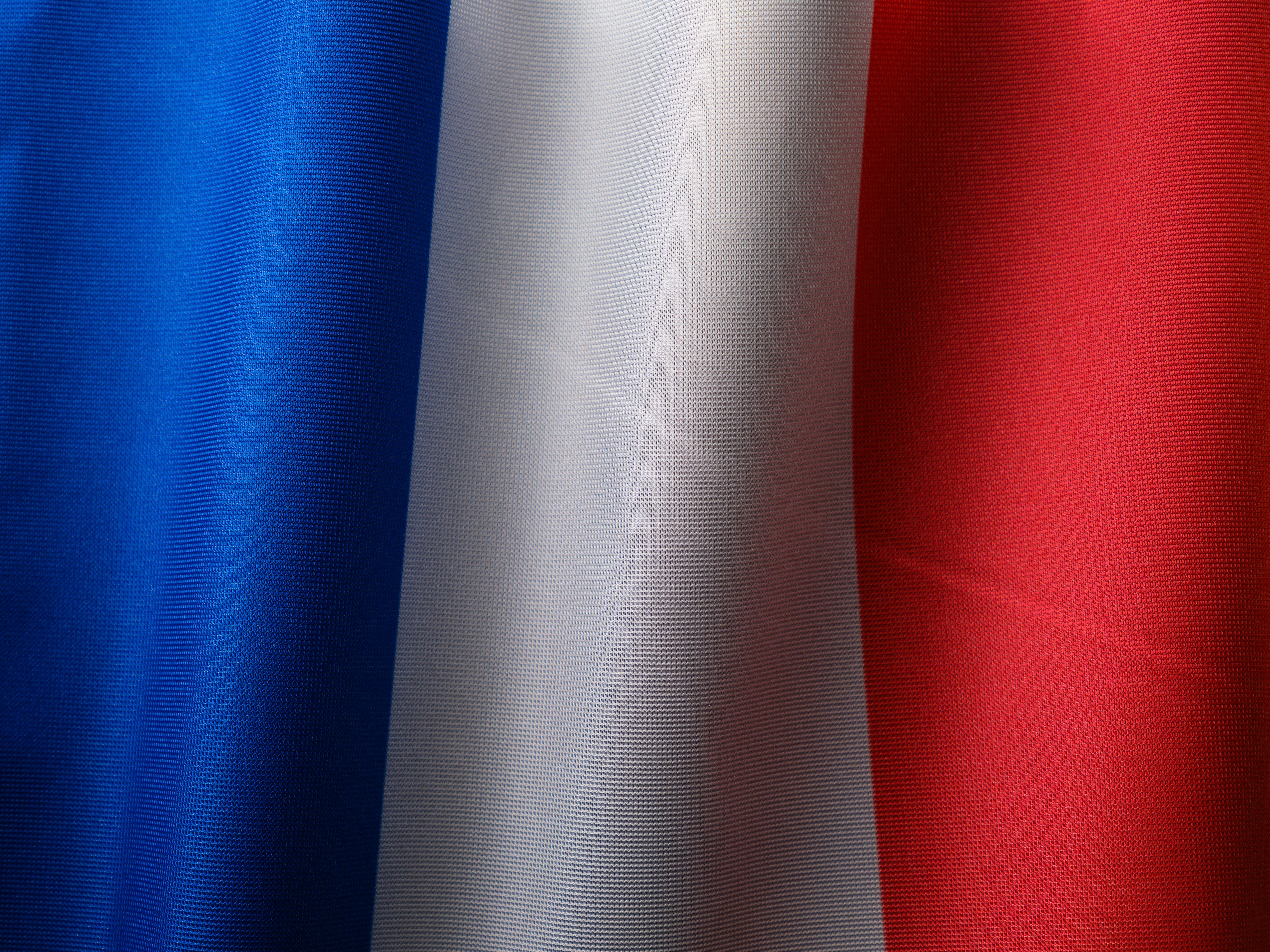 Close-up of the French flag with blue, white and red vertical stripes.