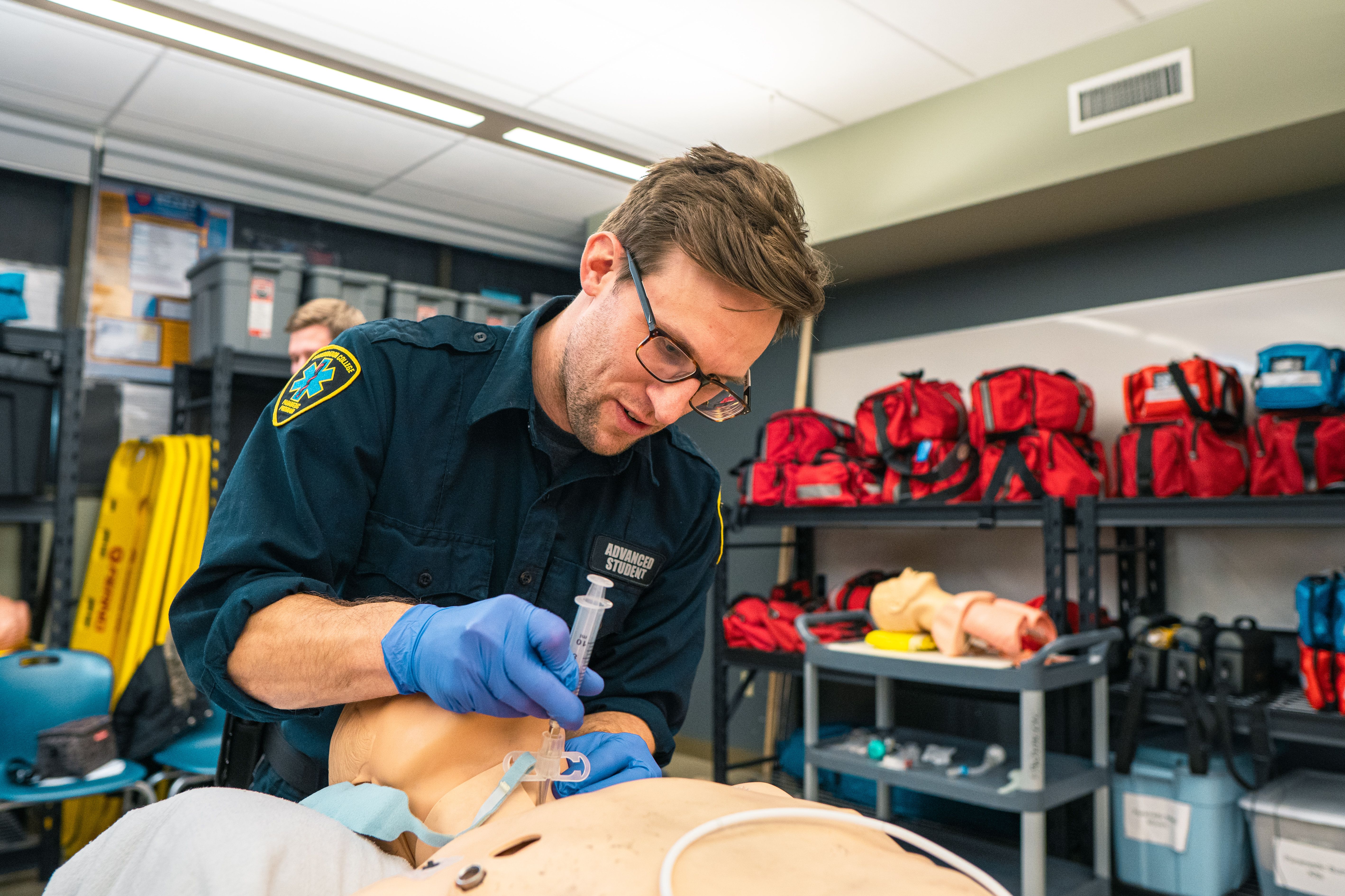 An ACP student practicing an injection procedure on a medical mannequin in the skills lab