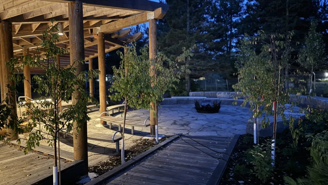 Illuminated wooden pavilion and walkway at night on campus