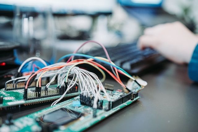 Student working with an electronic circuit board and wiring during computer engineering training