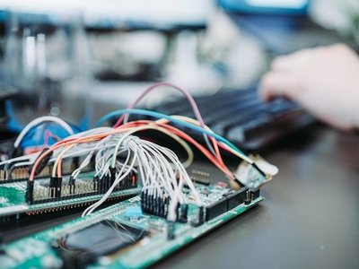 Student working with an electronic circuit board and wiring during computer engineering training