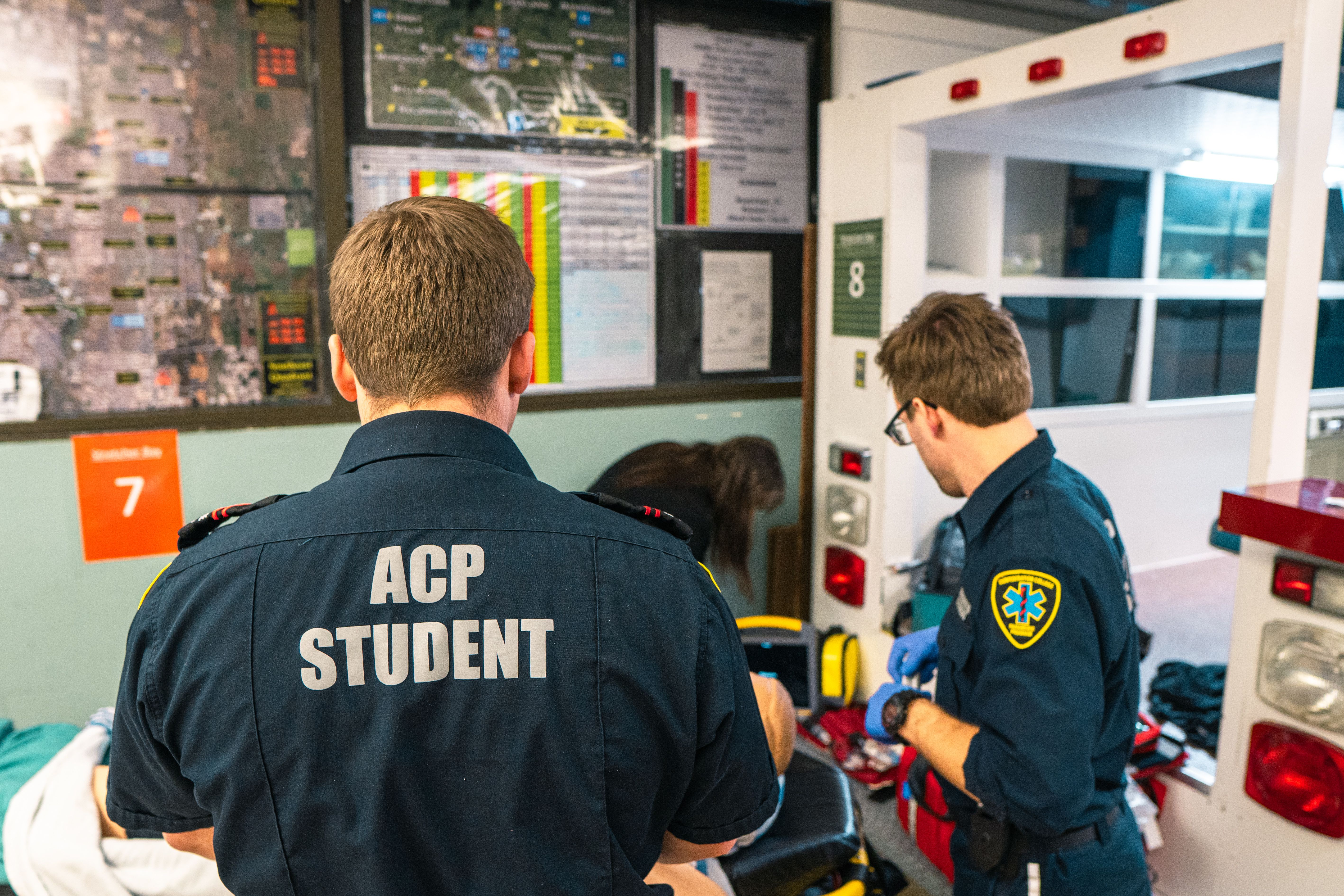 ACP students working together during a simulated emergency beside an ambulance bay