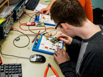 Industrial Electrician apprentices wiring components on a breadboard in a lab