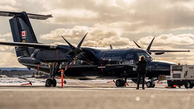 Royal Canadian Air Force aircraft on airport tarmac with ground crew and equipment