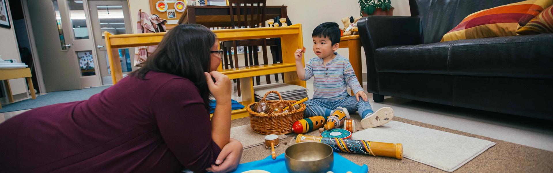 Woman and child playing at home near wicker basket