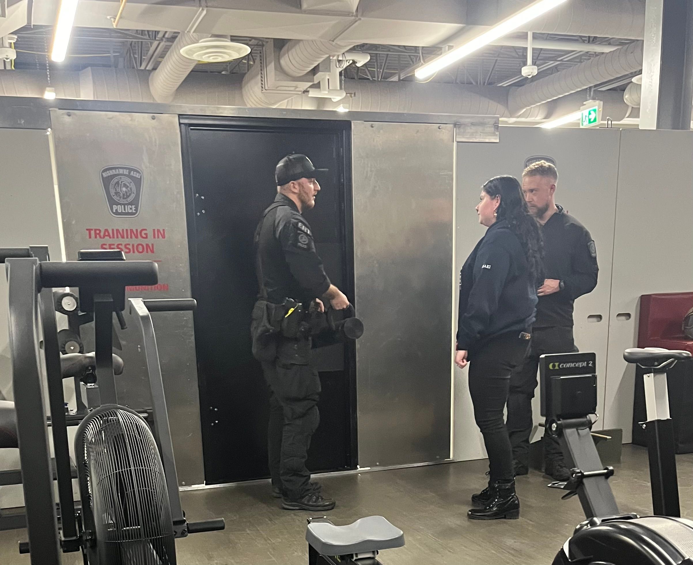 Police officers brief trainees during an indoor tactical training session