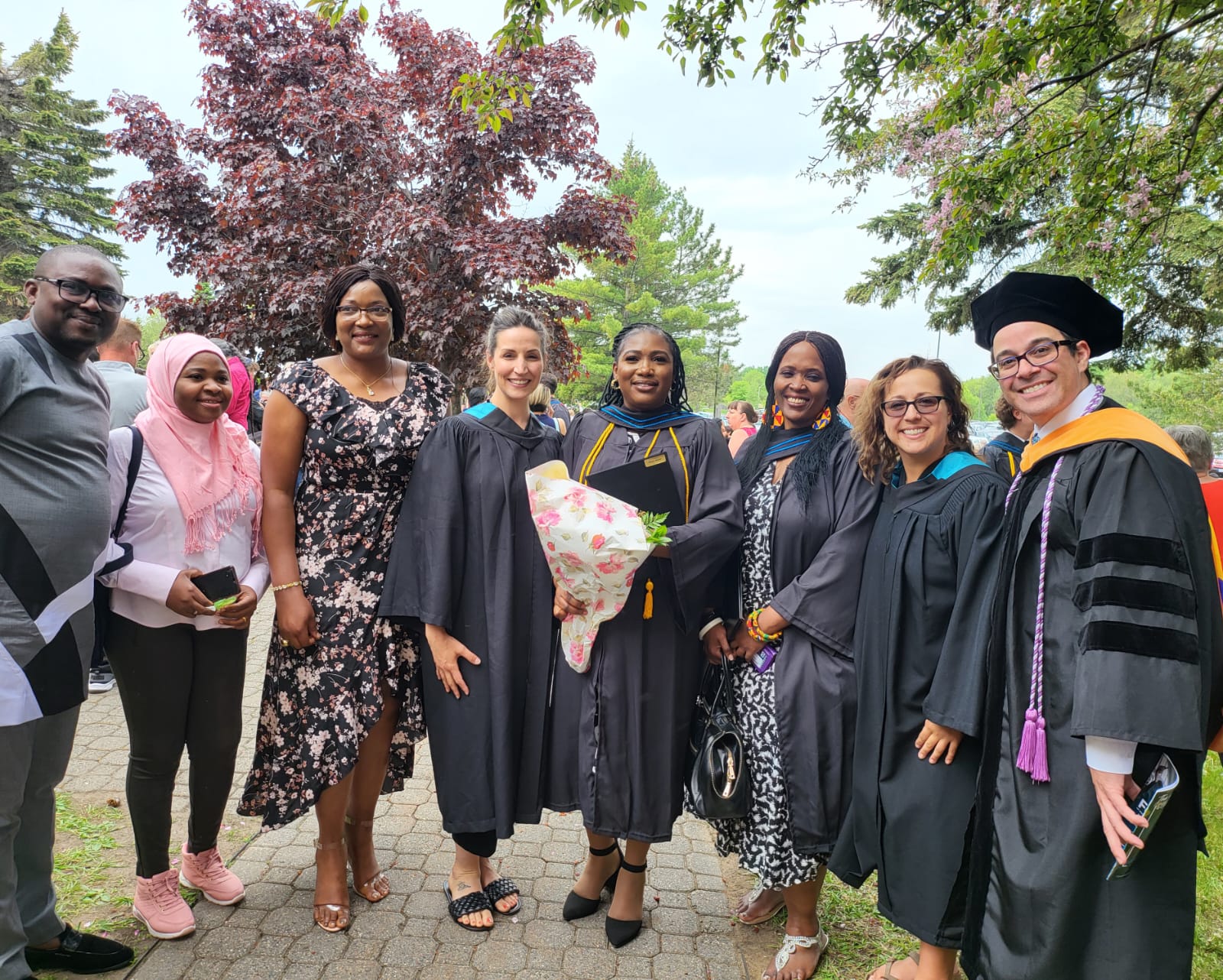 Graduates and family members celebrate outdoors at Confederation College convocation.