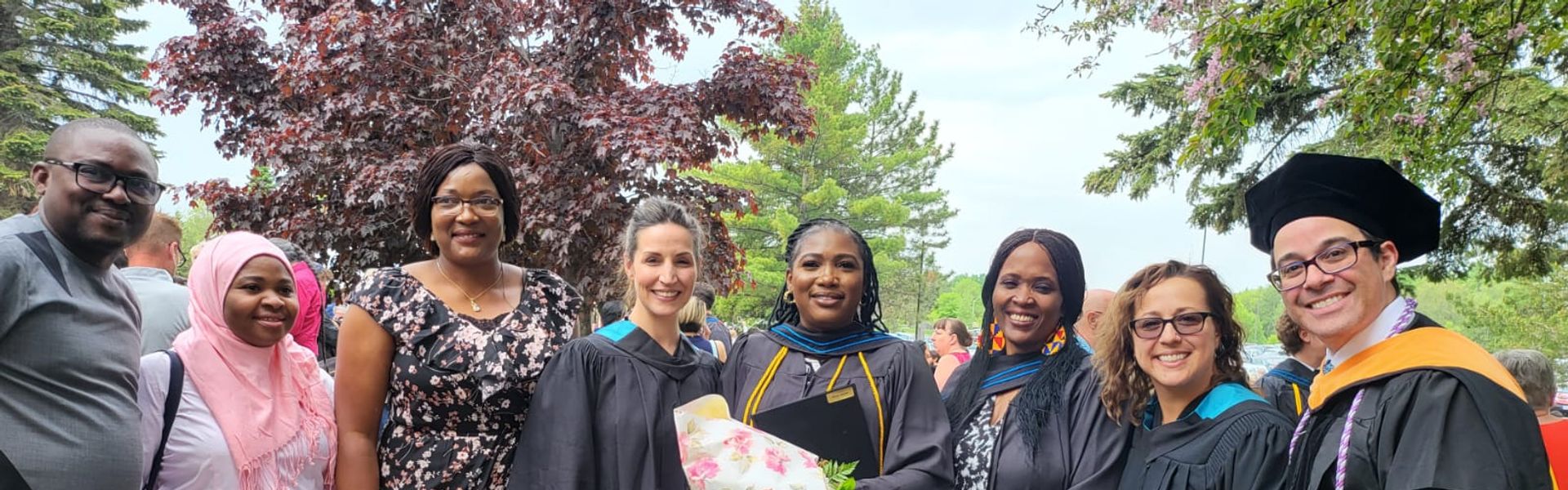 Graduates and family members celebrate outdoors at Confederation College convocation.