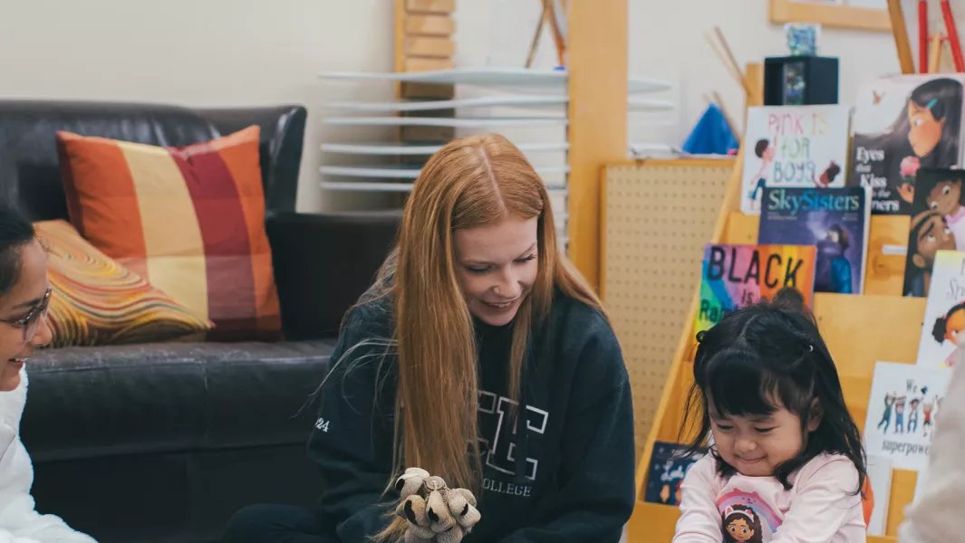 Student engaging a young child in play-based learning activities