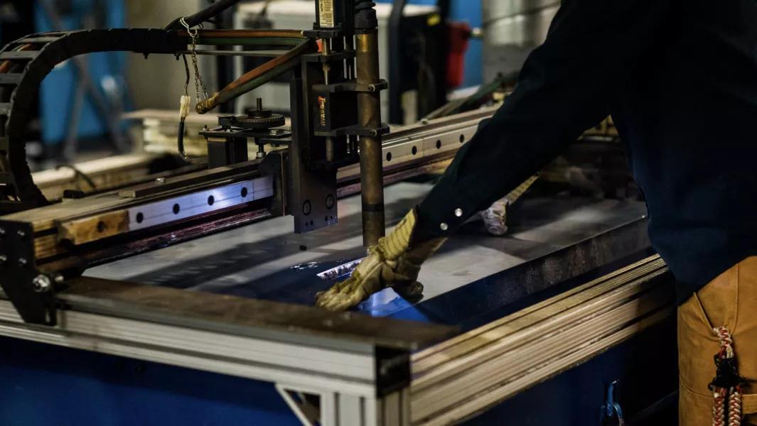 Student operating a CNC cutting machine during hands on manufacturing training