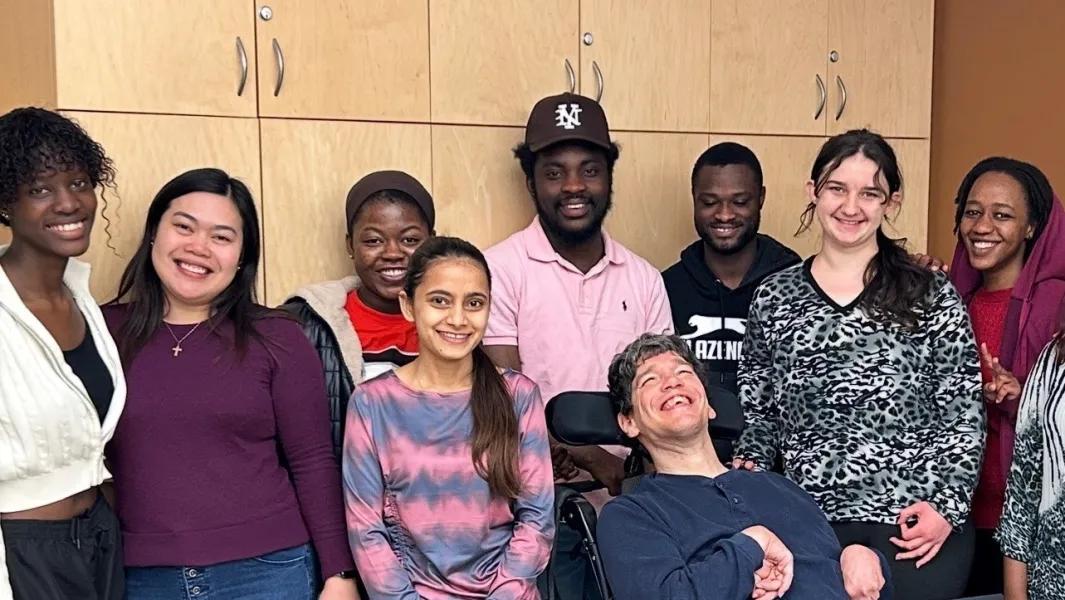 Students posing with a peer using a wheelchair during program activities