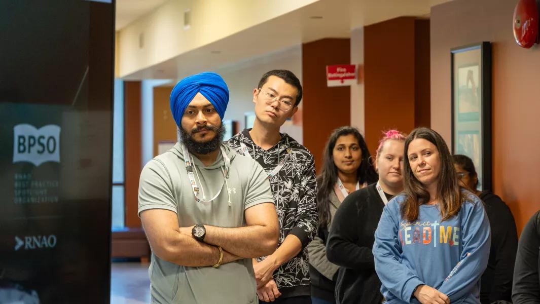 Students standing together listening during a Confederation College event