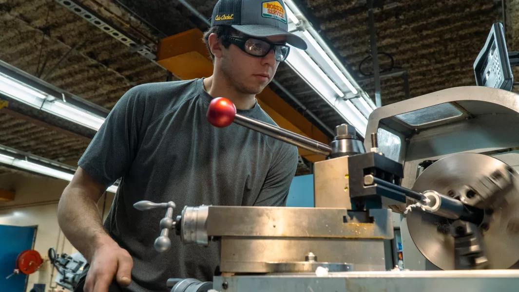 Student operating a metal lathe in the workshop
