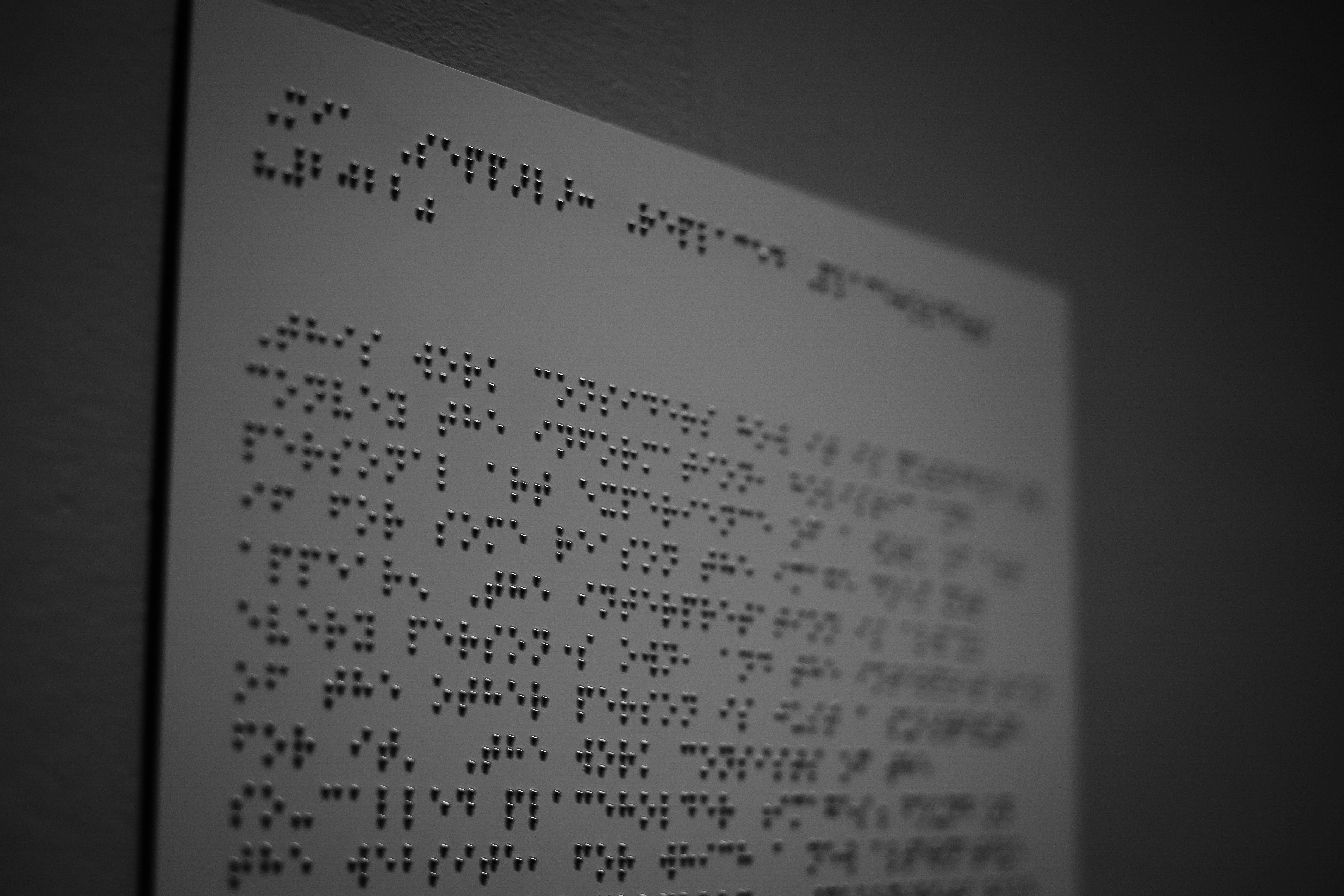 Close-up of a Braille page with raised dot patterns on a white sheet