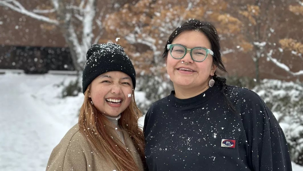 Two smiling girls with a snowy background