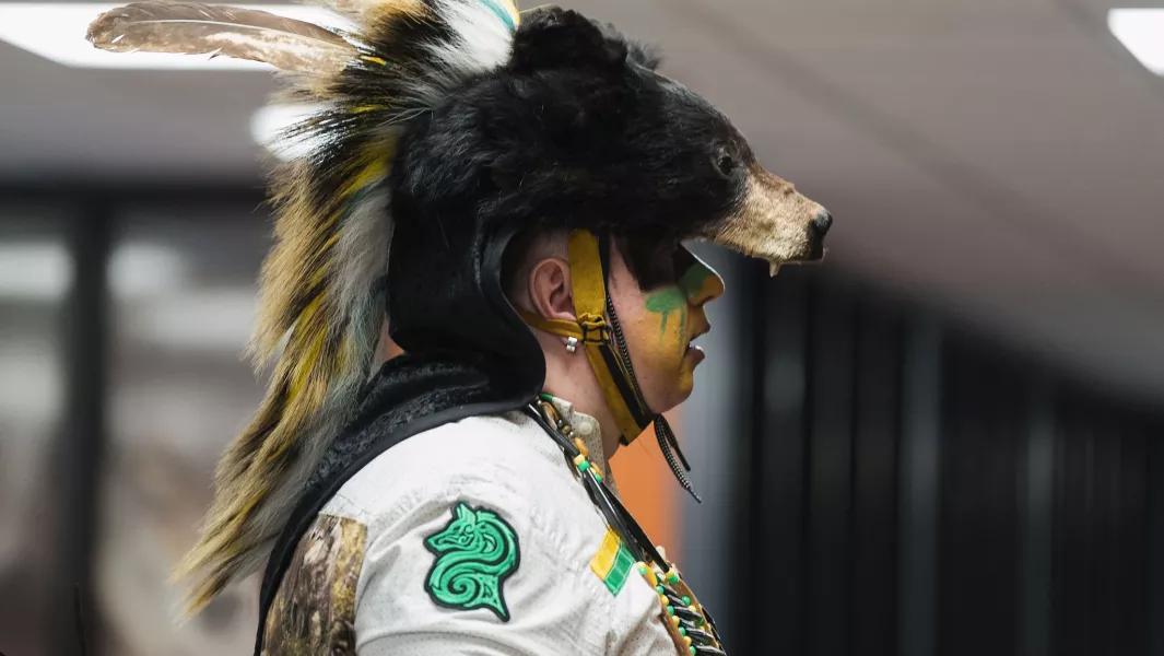 Participant in detailed traditional attire with a fur headdress at a cultural celebration