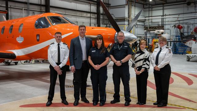 Ornge and Confederation College staff pose in front of an aircraft for the bursary announcement