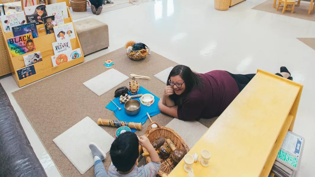Instructor interacting with a child during a play-based classroom activity