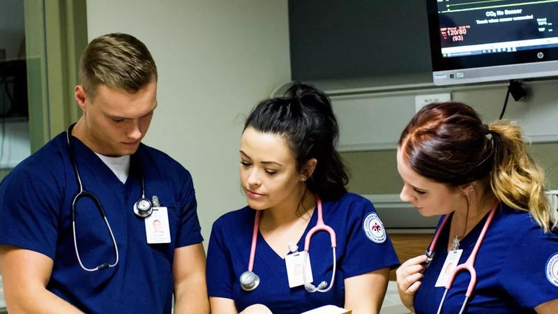 Nursing students reviewing notes together in a clinical simulation lab