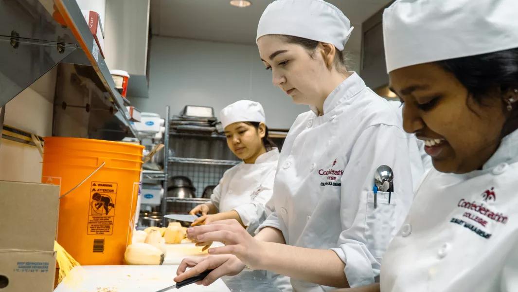 Culinary students preparing ingredients at the workstation