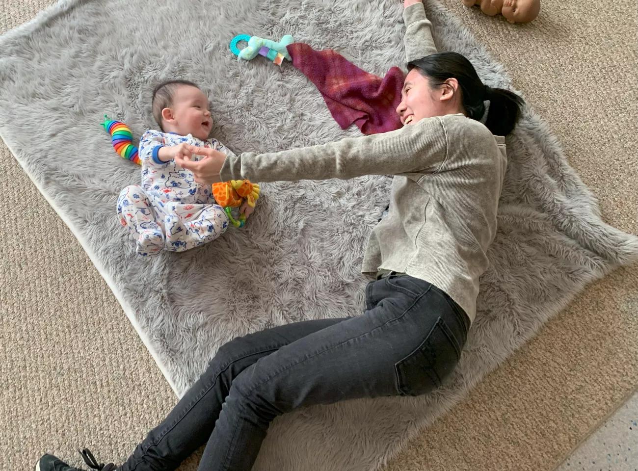 A woman playing with a toddler