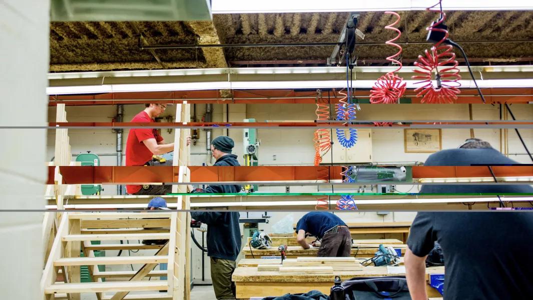 Carpentry students building wooden stair framing in a hands-on workshop classroom