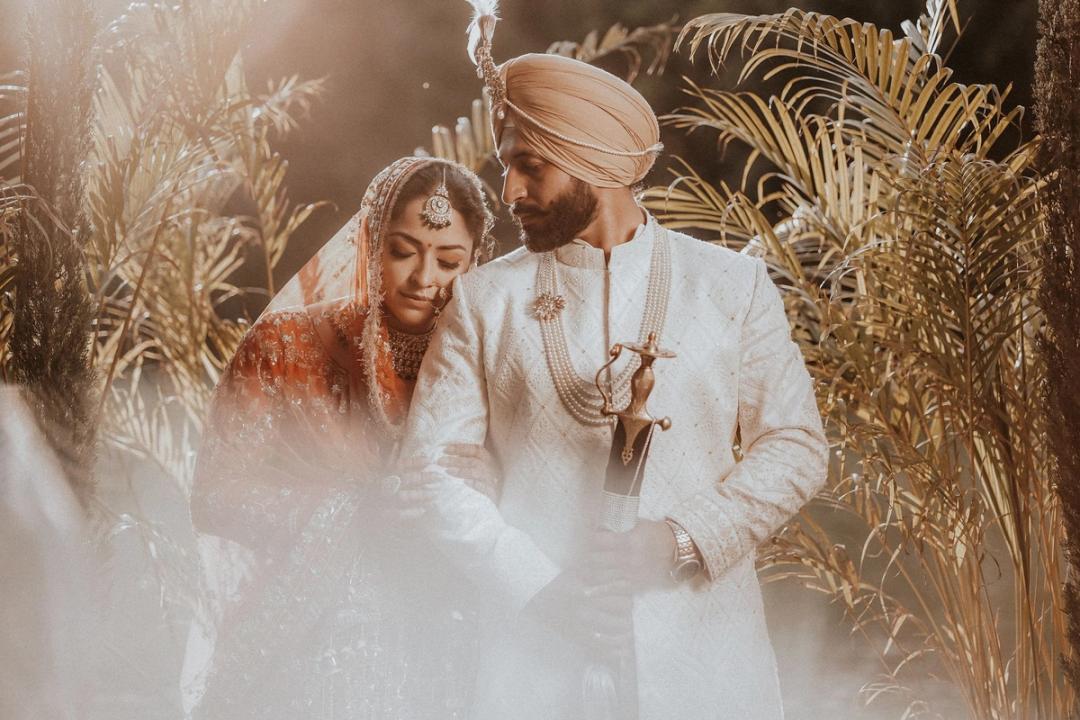 Couple in soft golden light among dried grasses