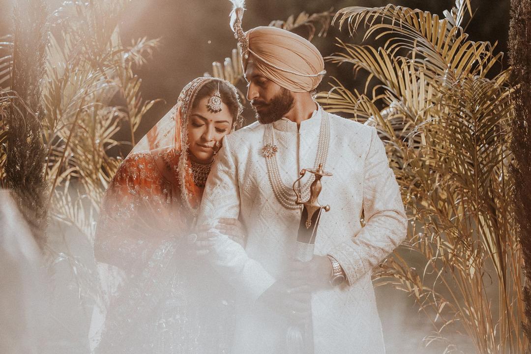 Couple in soft golden light among dried grasses