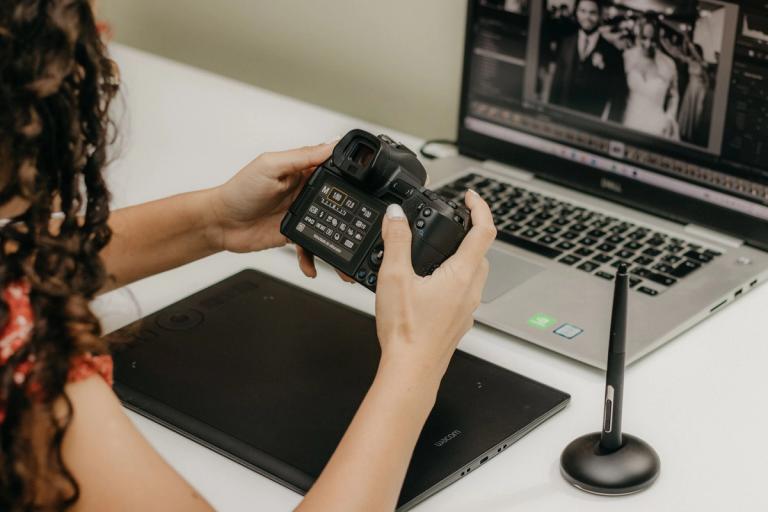 Photographer with a camera at a laptop, editing photos