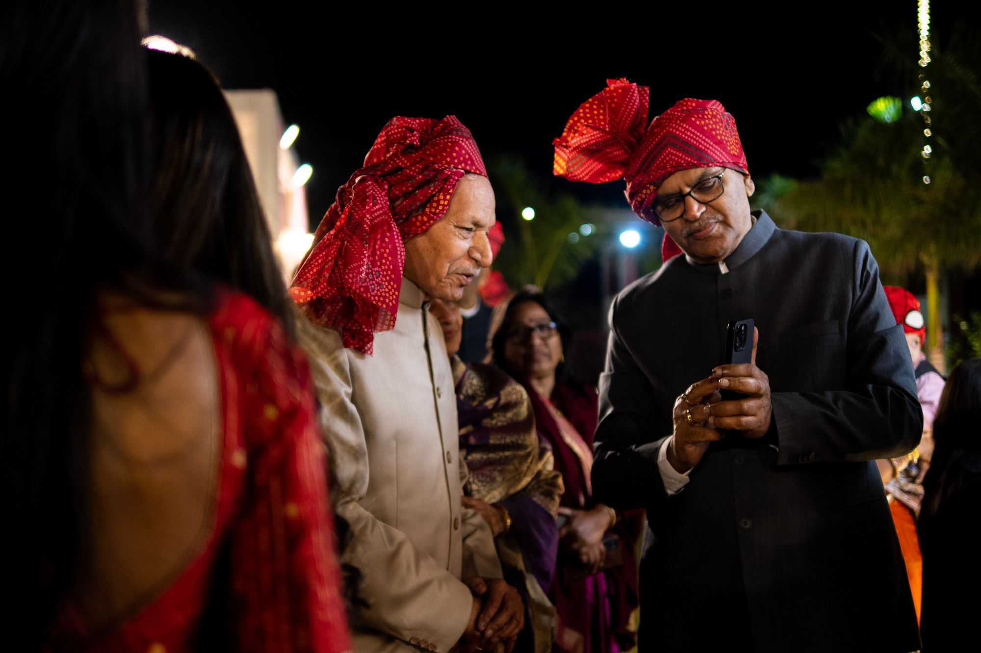 Family elders looking at photos on a phone at the wedding